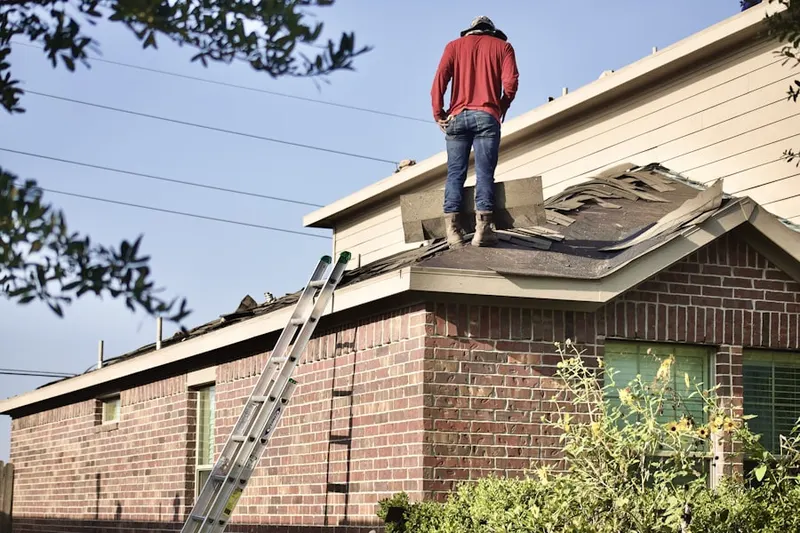 Professional roofer working on a residential roof in Peapack